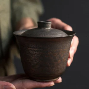 Full set of antique bronze ceramic gaiwan and matching teaware on a dark wood tea table