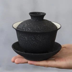 Full three-piece black speckled stone texture gaiwan set on neutral background