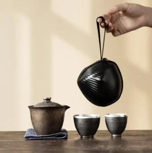 Full travel gaiwan tea set laid out with carrying bag, gaiwan, two tea cups, and tea cloth