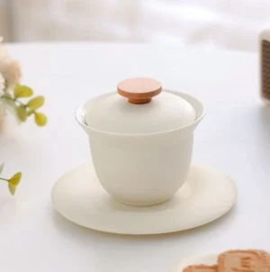 Full set of creamy white porcelain gaiwan with natural wooden handle on lid, showing complete 3-piece tea set