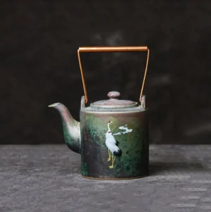 Full view of handcrafted crane and cloud vintage chinese teapot with copper metal handle