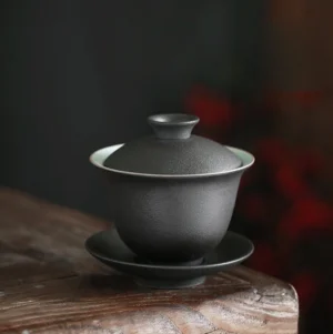 Full view of handmade matte black ceramic gaiwan, traditional three-piece Chinese Gongfu tea set