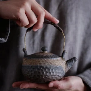 Full side view of handmade textured 8oz wabi-sabi Chinese ceramic teapot with brass wrapped handle