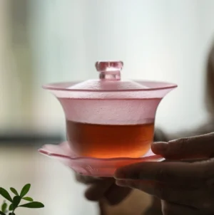 Full view of pink frosted glass gaiwan with floral lid and petal saucer