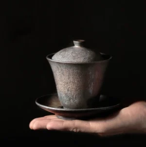 Full view of vintage bronze ceramic gaiwan with bowl lid and saucer